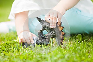 Toddler kid playing with a toy dinosaur