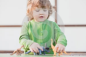 Toddler kid playing with a toy dinosaur