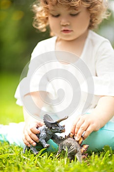 Toddler kid playing with a toy dinosaur