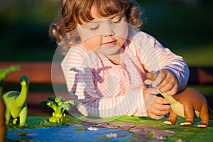 Toddler kid playing with a toy dinosaur.