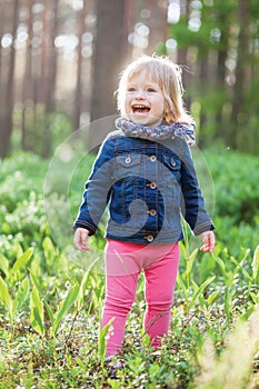 Toddler laughing girl in forest