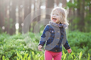 Toddler laughing stylish girl in forest