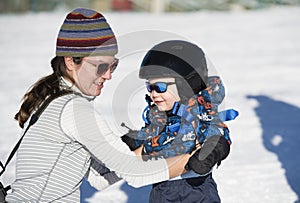 Toddler Learns to Ski with Mom. Dressed Safely with Helmet