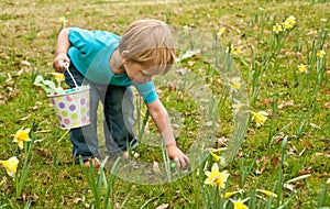 Toddler picking up Easter egg