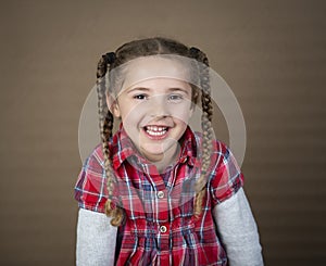 Toddler in pigtails and red plaid shirt