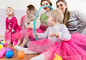 Toddler in pink dress playing with hula hoop