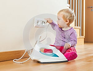 Toddler playing with electric iron