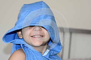 Toddler playing and hiding on his blue T-shirt.