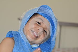 Toddler playing and hiding on his blue T-shirt.