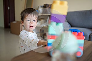 Toddler playing with his toy cars in the living room