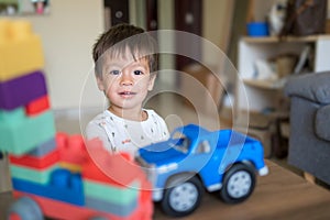 Toddler playing with his toy cars in the living room