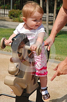 Toddler playing on horse tetter-totter photo