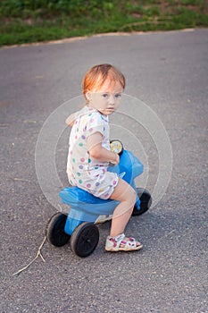 Toddler playing riding a toy bike at the street