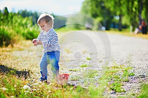 Toddler playing with sand molds, bucket and shovel