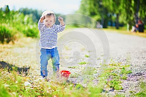 Toddler playing with sand molds, bucket and shovel