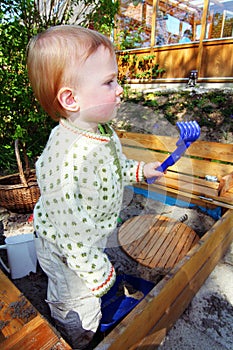 Toddler playing in sandbox