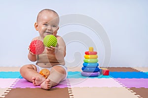 A toddler plays with rubber balls to develop hand motor skills