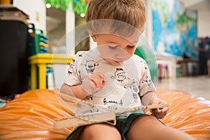 Toddler Reading a Book in a Public Library