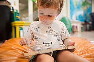 Toddler Reading a Book in a Public Library