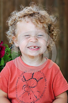 Toddler with ringlets & missing tooth photo