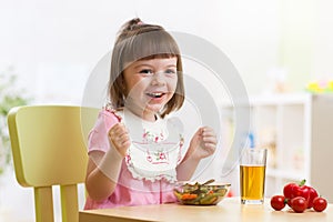 Toddler sitting at table food ready to eat in the nursery.