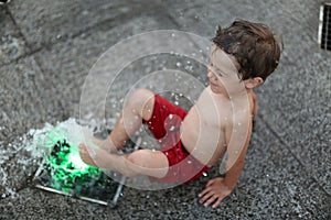 Toddler in a splashing water fountain