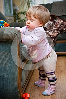 Toddler standing by chair