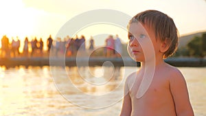 Toddler standing on the seashore during sunset. Mental health. Children psychology. Facial expression. Special look