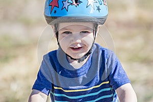 Toddler on a Strider Bike at a Dirt Track Wearing Helmet