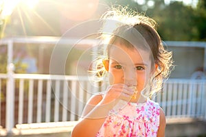 Toddler at sunset eating a cookie