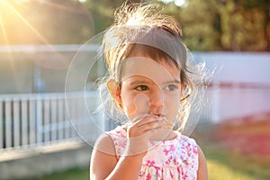 Toddler at sunset eating a cookie