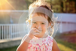 Toddler at sunset eating a cookie