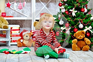 Toddler with toy car by the Christmas tree