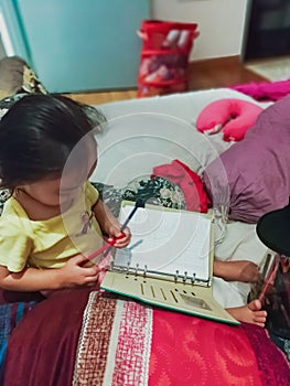Toddler using book to draw and learn
