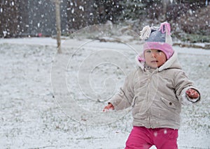 Toddler Walking While Its Snowing Out photo