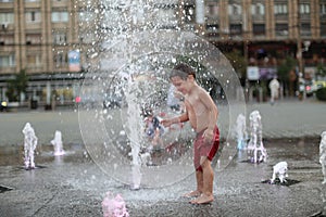 Toddler walking in a splashing water fountain