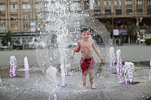 Toddler walking in a splashing water fountain