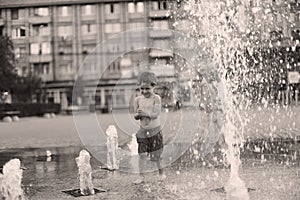 Toddler walking in a splashing water fountain