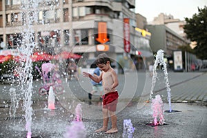 Toddler walking in a splashing water fountain