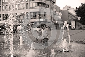 Toddler walking in a splashing water fountain