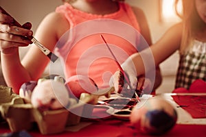 Toddlers having fun painting Easter eggs.