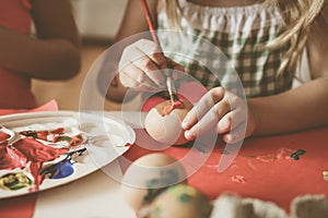 Toddlers having fun painting Easter eggs.