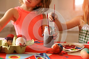 Toddlers having fun painting Easter eggs.