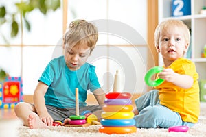 Toddlers kids playing with wooden blocks at home photo