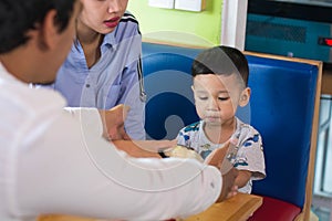 Todler id with his parents eating cake inside cafe