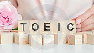 Toeic text on wooden block in hand, concept