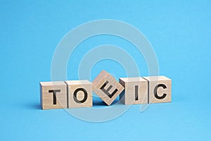 TOEIC text on wooden blocks, business concept, blue background