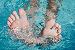 Toes peeking out of the water. Foot with the pool background. Toes close up