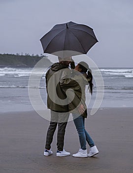 Tofino Vancouver Island, couple in rain coat during stormy weather and rain on long beach Tofino