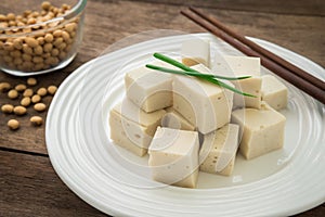 Tofu cubes on plate and soy beans in bowl